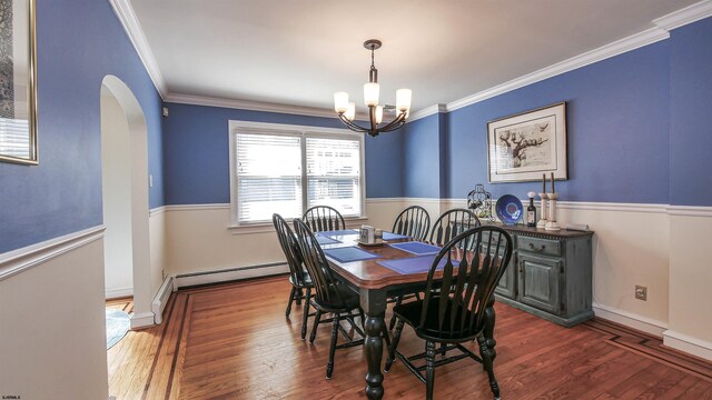 dining space with an inviting chandelier, crown molding, dark wood-type flooring, and a baseboard heating unit