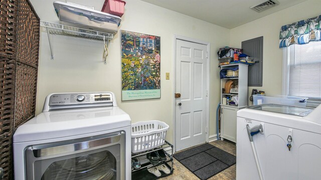 clothes washing area featuring tile floors, cabinets, and washer and clothes dryer