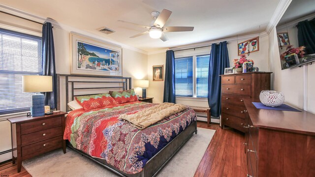 bedroom featuring ceiling fan, a baseboard radiator, dark wood-type flooring, and crown molding