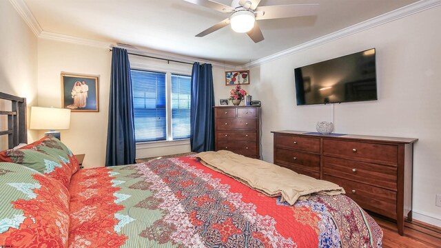 bedroom featuring dark hardwood / wood-style flooring, ceiling fan, and ornamental molding