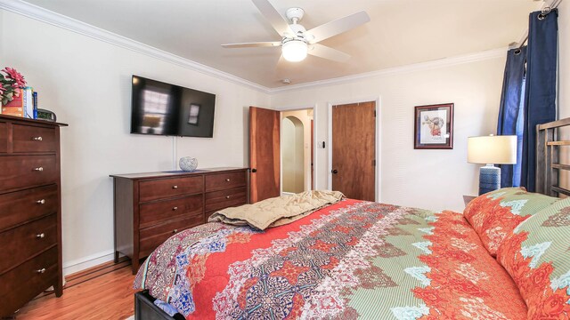 bedroom with ceiling fan, light wood-type flooring, and crown molding