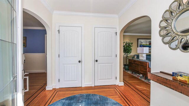 foyer entrance with dark hardwood / wood-style flooring and crown molding