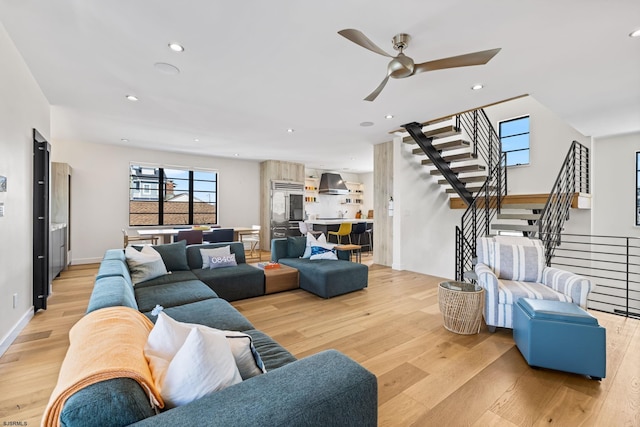 living room with ceiling fan and light wood-type flooring