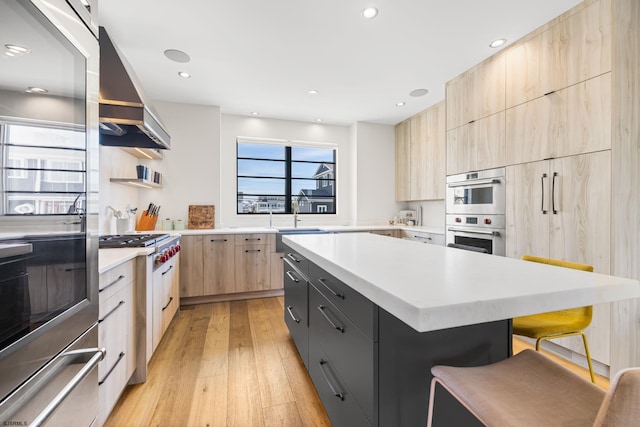 kitchen featuring light brown cabinets, premium range hood, double oven, light hardwood / wood-style floors, and a breakfast bar