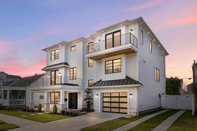 view of front of house with a yard, a garage, and a balcony