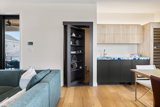 bar featuring light brown cabinets and light hardwood / wood-style flooring