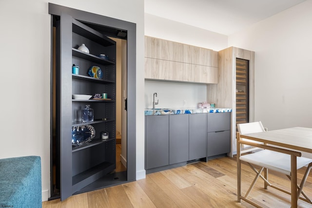 interior space featuring light brown cabinetry, sink, and light wood-type flooring