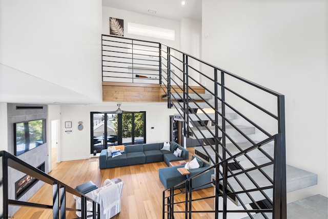 staircase featuring light hardwood / wood-style floors, plenty of natural light, and a towering ceiling