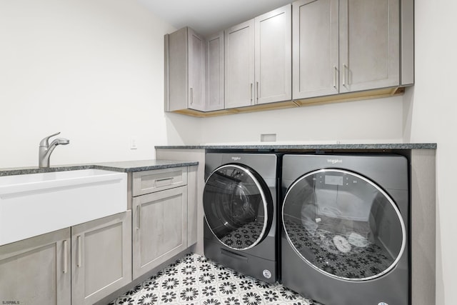 laundry area with cabinets, light tile floors, sink, and washer and clothes dryer