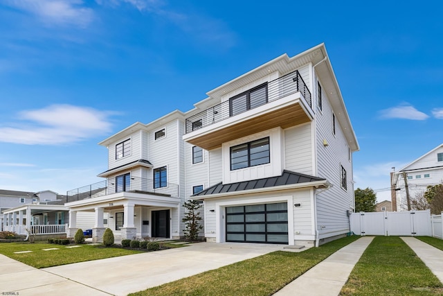 view of front facade featuring a garage, a balcony, and a front yard