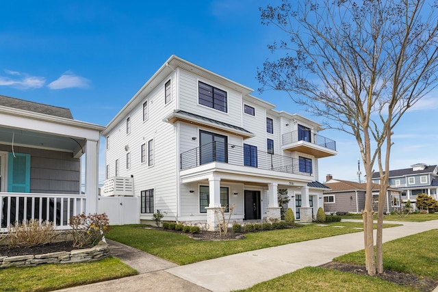 view of front of home with a front lawn and a balcony