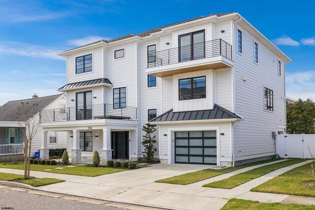 view of front of house with a garage, a balcony, and a front yard