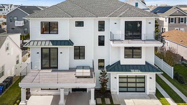 back of house with a garage and a balcony