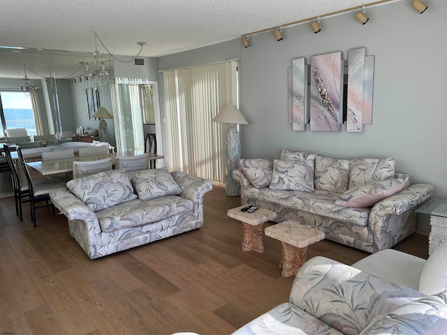 living room featuring a textured ceiling, a chandelier, and hardwood / wood-style flooring