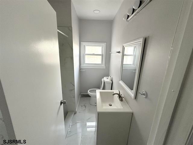 bathroom featuring vanity, tile flooring, and toilet