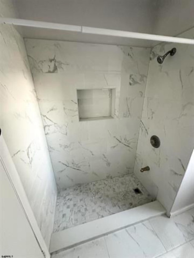 bathroom featuring tile flooring and tiled shower