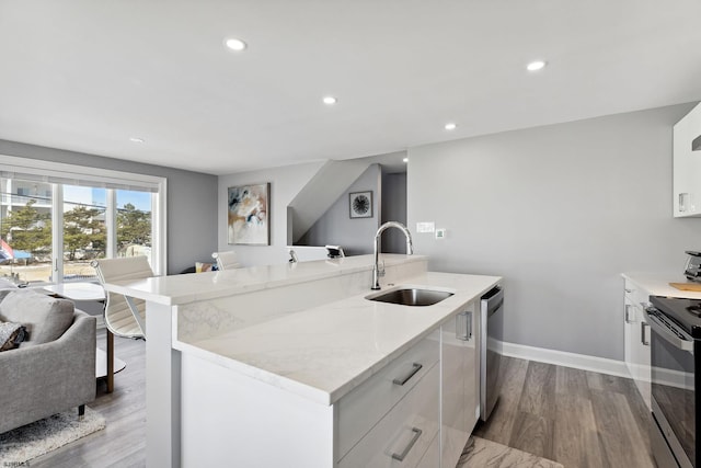 kitchen featuring white cabinets, sink, light hardwood / wood-style floors, and light stone countertops