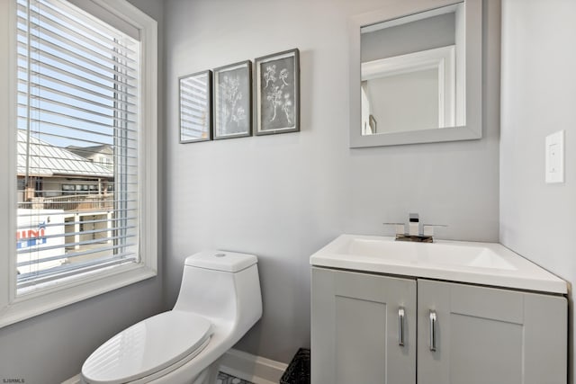 bathroom with a wealth of natural light, toilet, and vanity