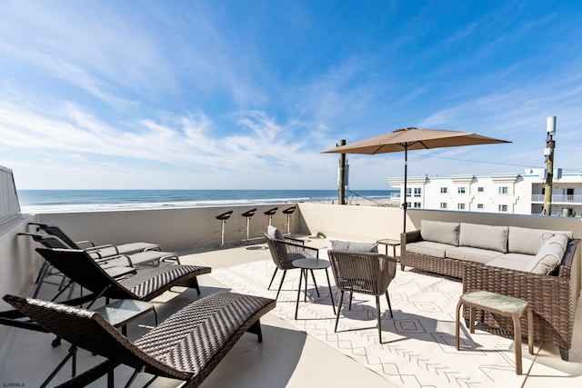 view of patio featuring an outdoor living space, a water view, and a beach view