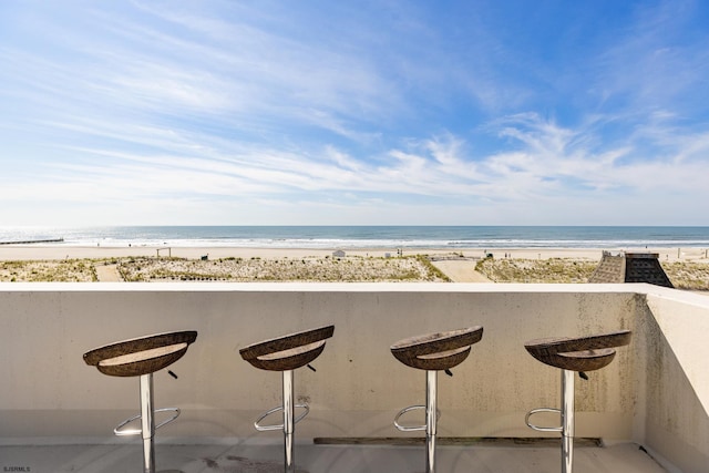 exterior space with a beach view, a water view, and a kitchen bar