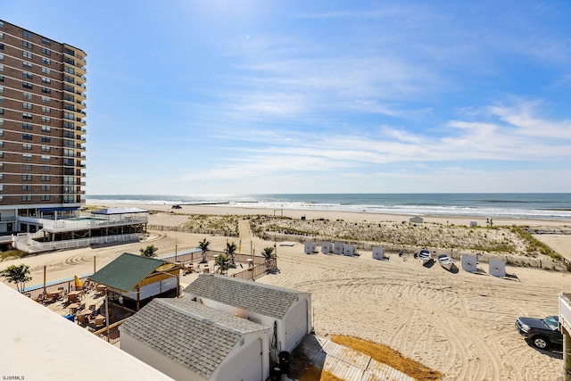 birds eye view of property with a water view and a beach view