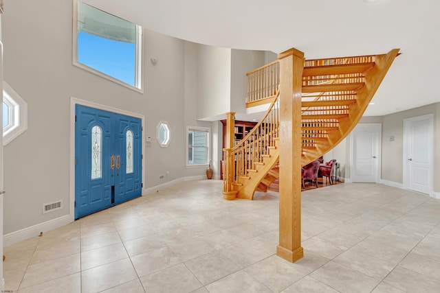 tiled foyer entrance featuring a towering ceiling