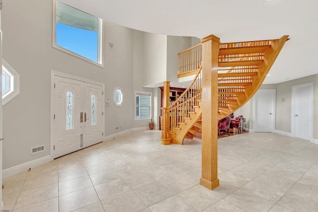 tiled foyer with a healthy amount of sunlight and a towering ceiling