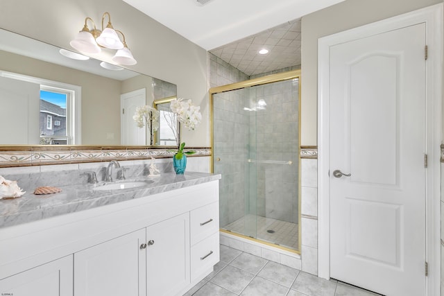 bathroom featuring vanity with extensive cabinet space, a shower with door, and tile flooring