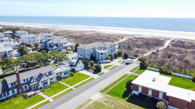 drone / aerial view with a water view and a beach view