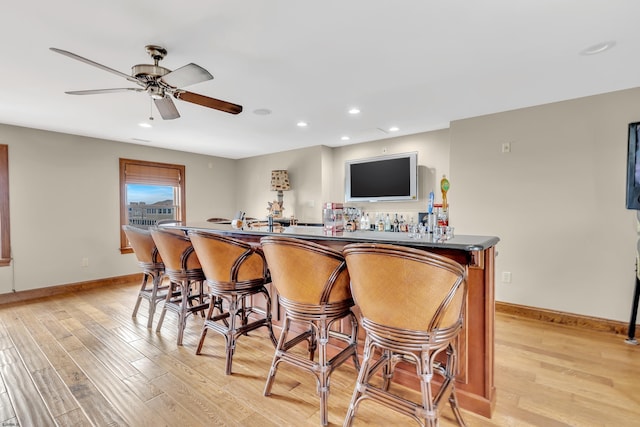 bar featuring light hardwood / wood-style flooring and ceiling fan