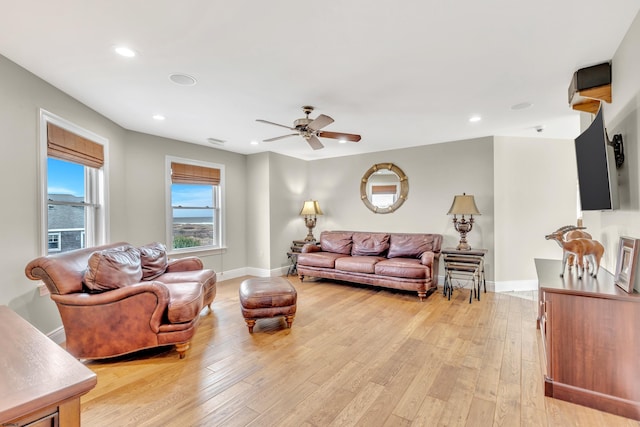 living room featuring ceiling fan and light hardwood / wood-style floors