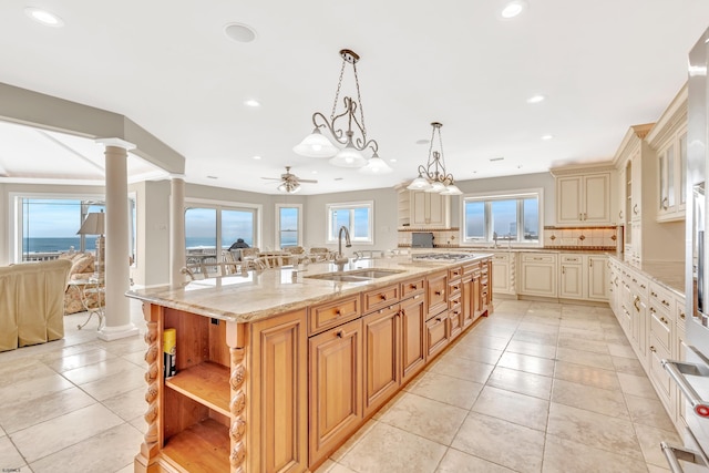 kitchen featuring sink, pendant lighting, light tile floors, and a kitchen island with sink