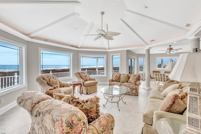 living room with a water view, a wealth of natural light, ceiling fan, and decorative columns