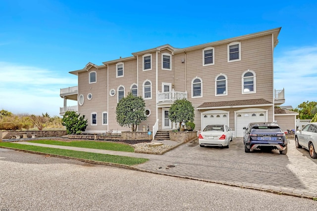 view of front of property featuring a garage and a balcony