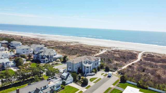 bird's eye view with a water view and a beach view