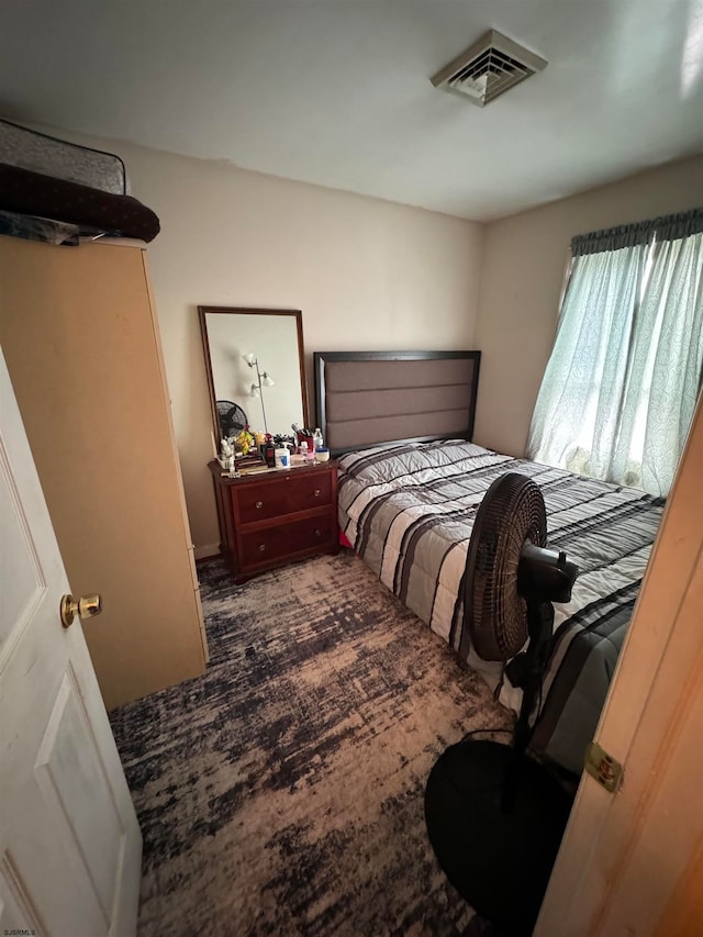 bedroom with dark colored carpet