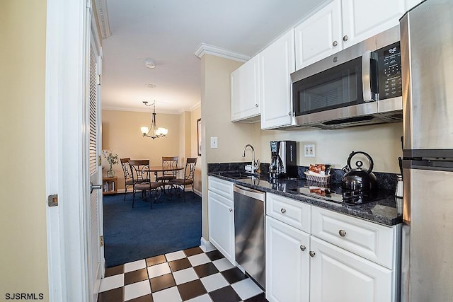 kitchen featuring hanging light fixtures, appliances with stainless steel finishes, light tile floors, and white cabinetry