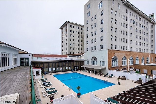 view of swimming pool featuring a patio area and a wooden deck