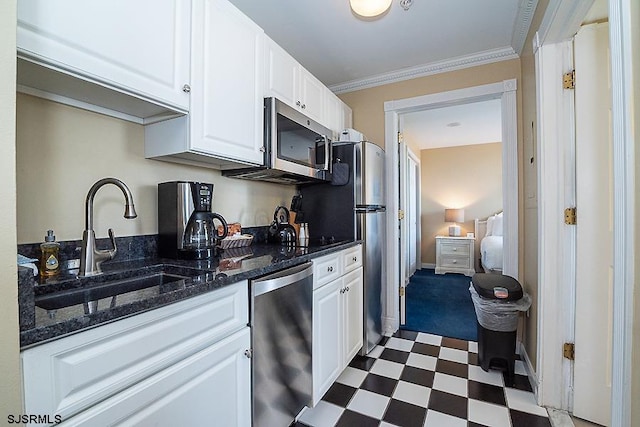 kitchen featuring sink, stainless steel appliances, white cabinetry, and tile flooring