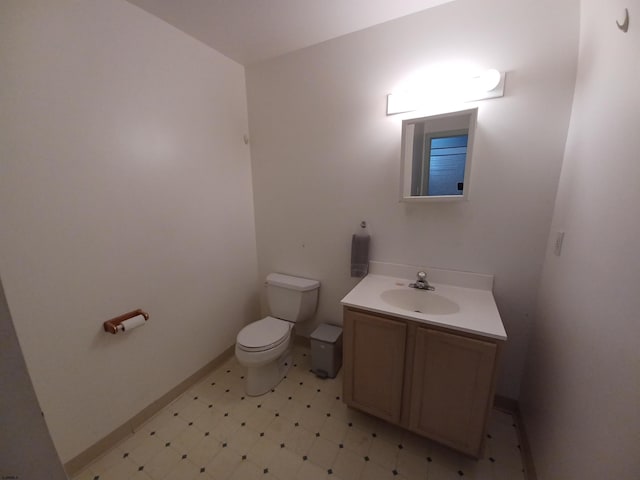 bathroom with vanity with extensive cabinet space, toilet, and tile flooring