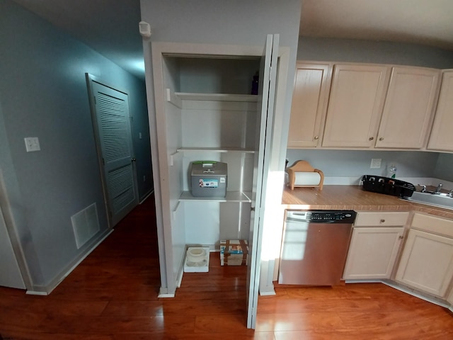 kitchen featuring stainless steel dishwasher, light wood-type flooring, and white cabinetry