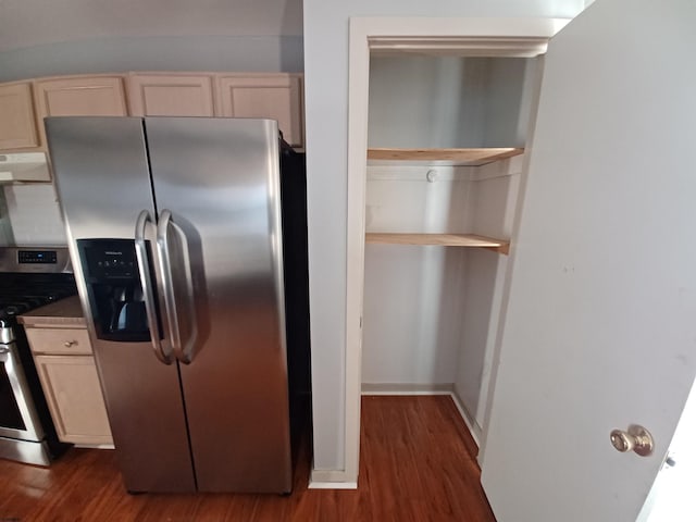 kitchen featuring light brown cabinets, dark hardwood / wood-style flooring, stainless steel appliances, and fume extractor