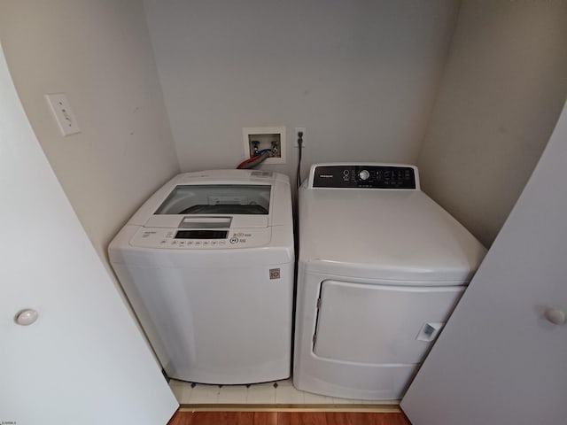 laundry area featuring independent washer and dryer, hookup for a washing machine, and light tile floors