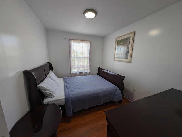 bedroom with dark hardwood / wood-style floors