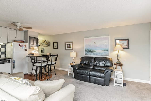 carpeted living room featuring ceiling fan and a textured ceiling