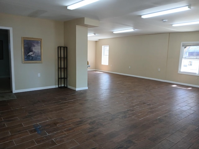 empty room with a wealth of natural light and dark wood-type flooring