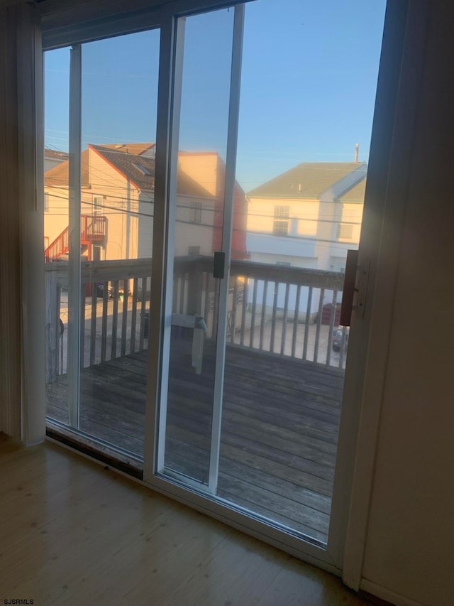 doorway with a healthy amount of sunlight and hardwood / wood-style floors