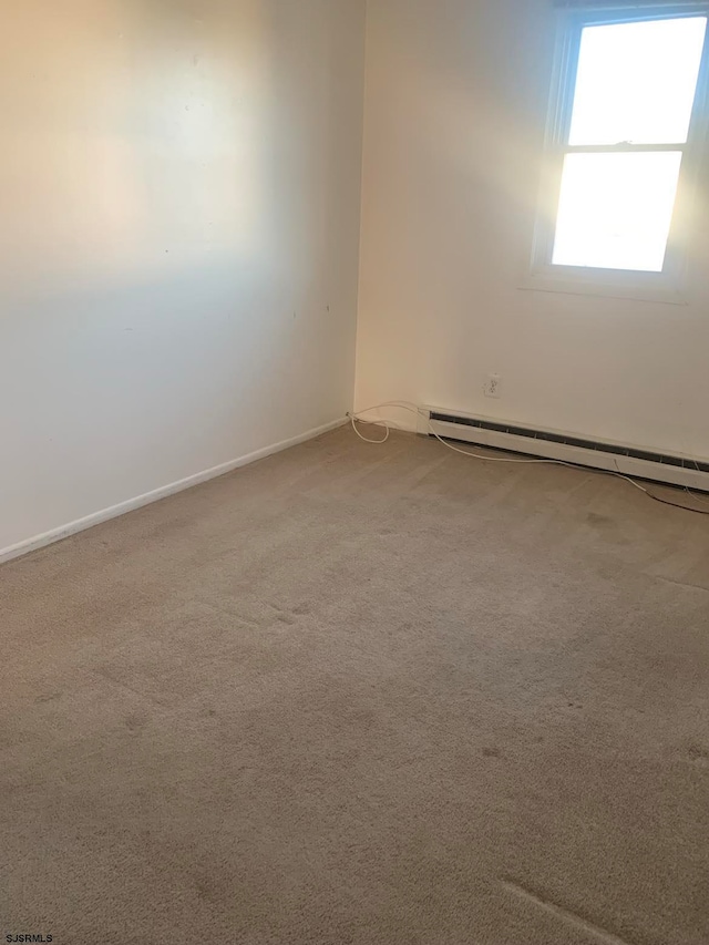 carpeted empty room featuring a baseboard radiator