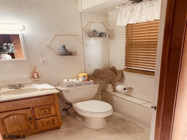 bathroom featuring tile flooring, vanity, and toilet