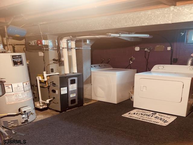 washroom with washing machine and dryer and gas water heater